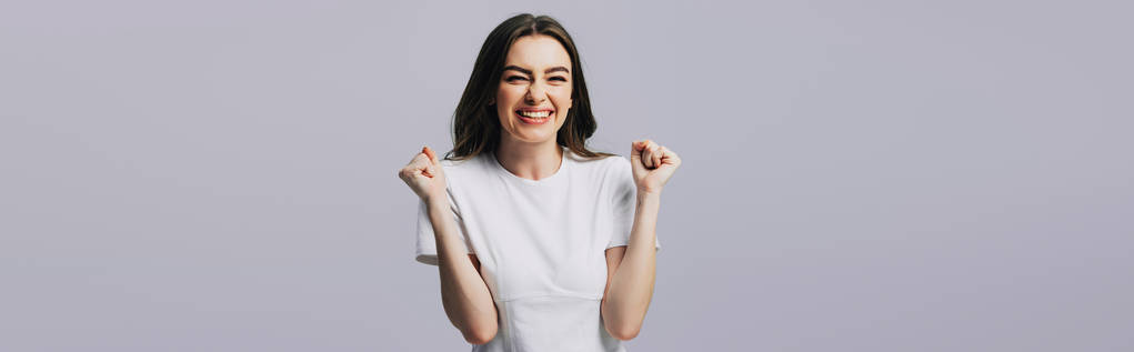 excited beautiful girl in white t-shirt showing yes gesture isolated on grey, panoramic shot - Photo, Image