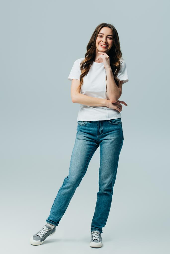 glücklich schönes Mädchen in weißem T-Shirt und Jeans isoliert auf grau - Foto, Bild