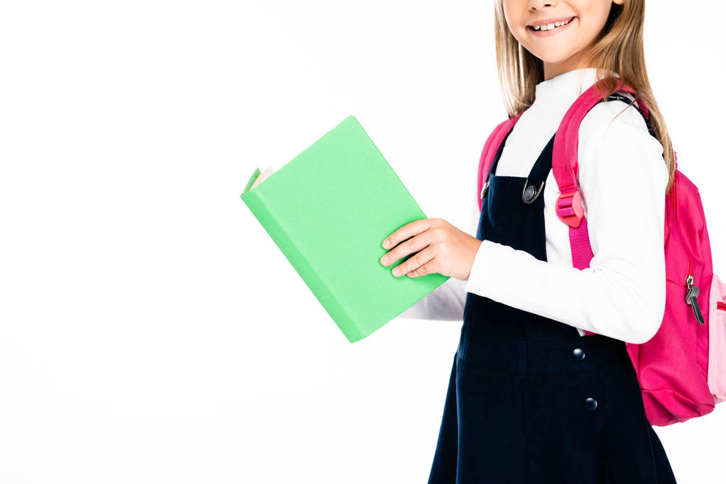 περικομμένη θέα του χαμογελαστή μαθήτρια κρατώντας το βιβλίο απομονωμένο σε λευκό - Φωτογραφία, εικόνα