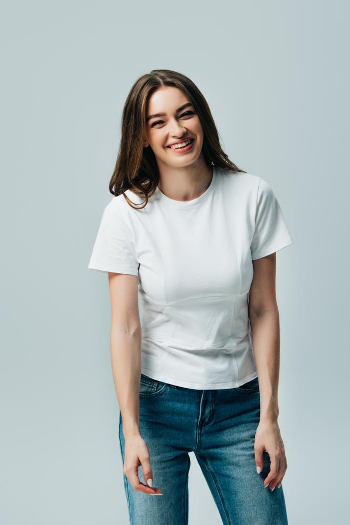 feliz riendo hermosa chica en blanco camiseta aislado en gris
 - Foto, Imagen
