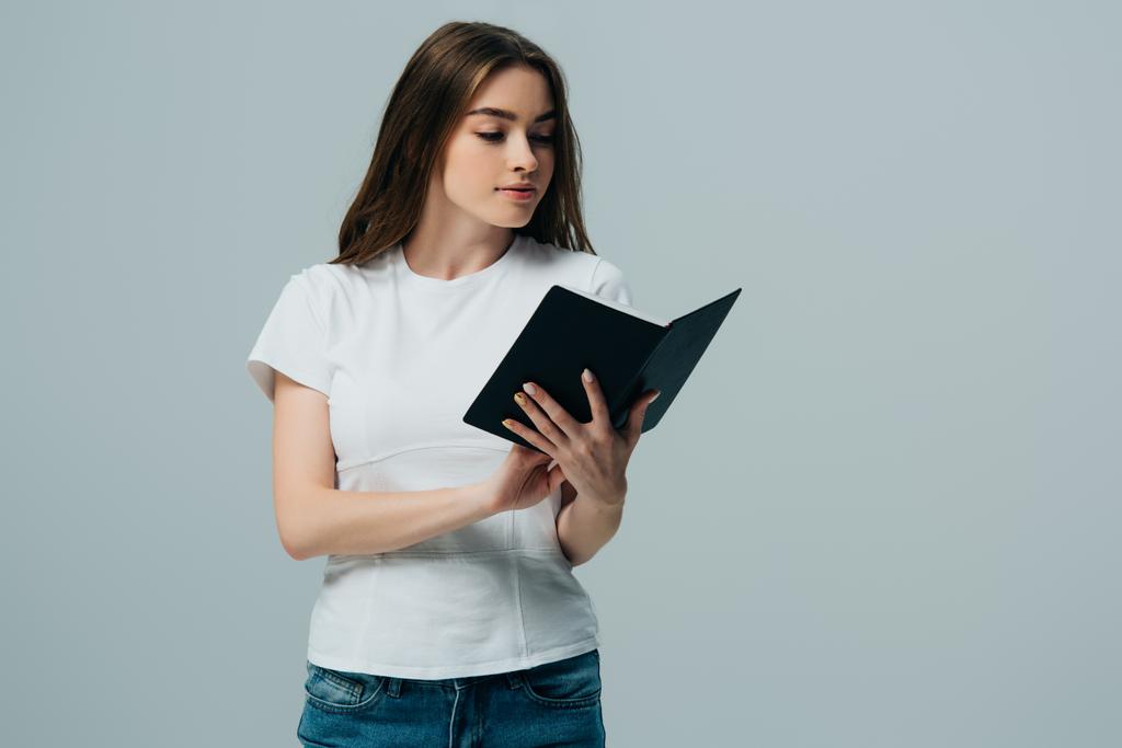 krásná dívka v bílém trička čtení kniha izolovaná na šedé - Fotografie, Obrázek
