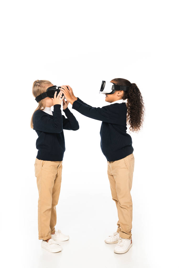volledige lengte weergave van twee multiculturele vrienden met behulp van Virtual Reality headsets op witte achtergrond - Foto, afbeelding