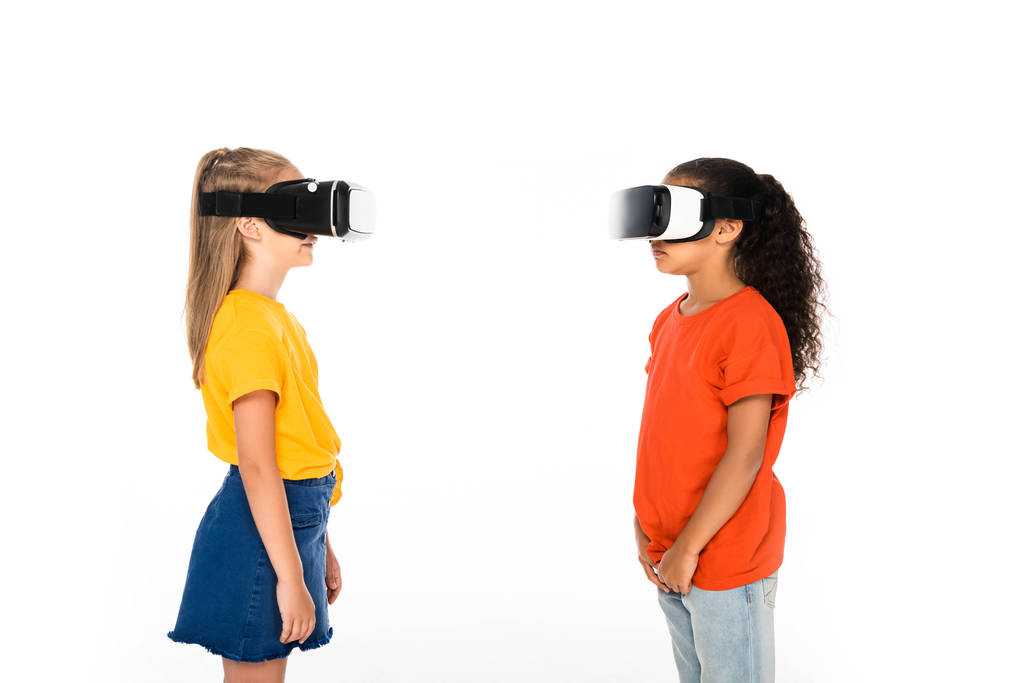 два мультикультурні друзі дивляться один на одного, використовуючи гарнітури віртуальної реальності ізольовані на білому
 - Фото, зображення