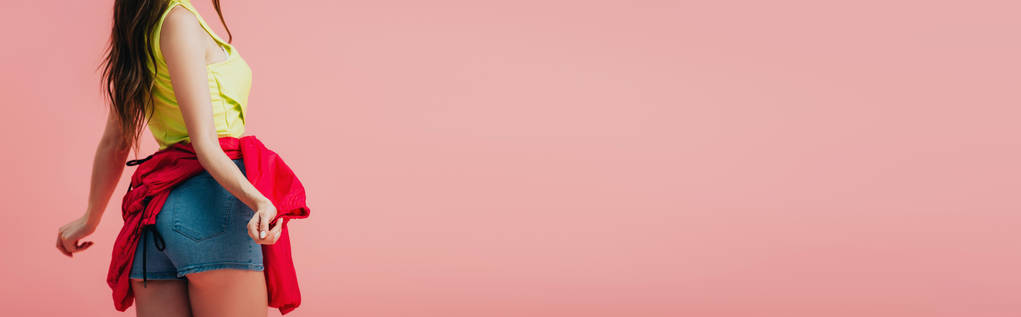 oříznutý pohled na krásnou dívku v jasných šatech tančících izolovaně na růžovém, panoramatickém záběru - Fotografie, Obrázek