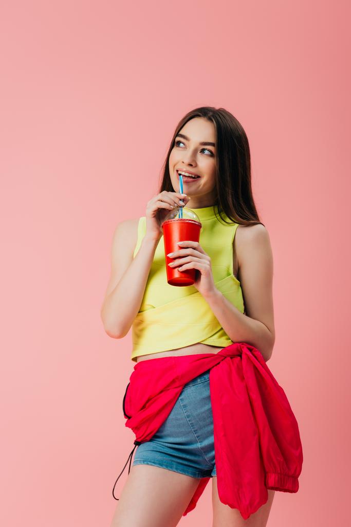 schönes lächelndes Mädchen in heller Kleidung trinkt Limo aus Stroh isoliert auf rosa - Foto, Bild