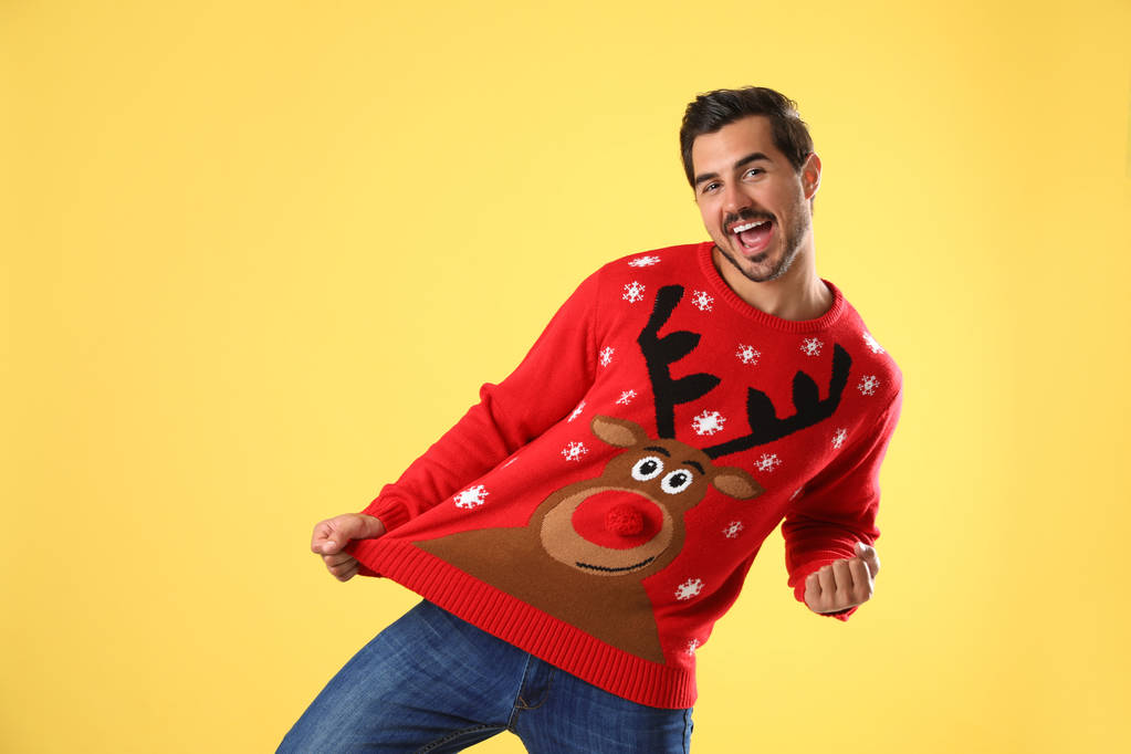 Portret van Happy Young Man in kerst trui op gele achtergrond - Foto, afbeelding