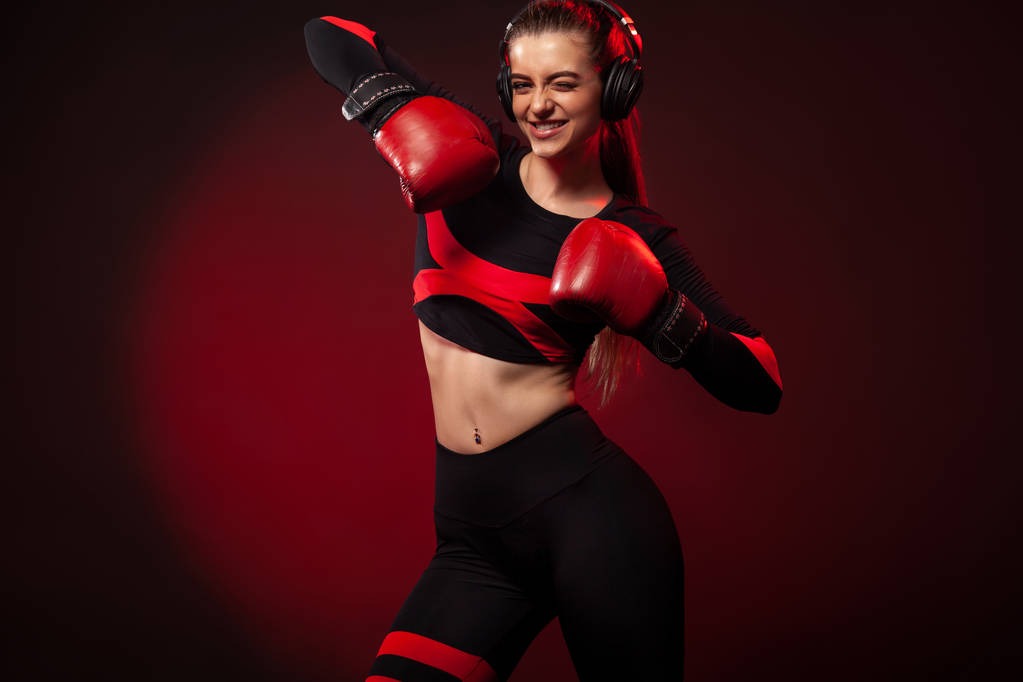 Счастливая и улыбающаяся молодая женщина боксер-спортсмен на боксерской тренировке. Девушка в перчатках, спортивной одежде
. - Фото, изображение
