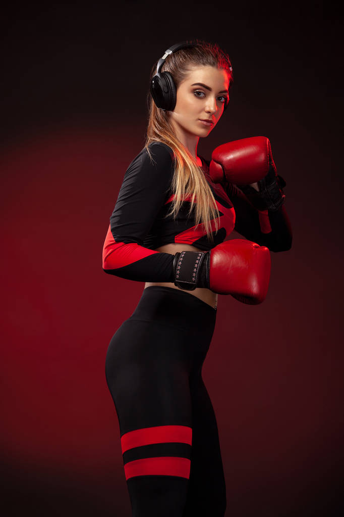Молода жінка спортсмен боксер на тренуваннях з боксу. Дівчина в рукавичках, спортивному одязі
. - Фото, зображення