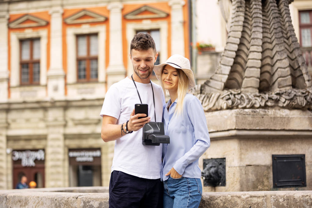 Bir şehir rehberi ve sokakta arama yerlerde akıllı telefon gps danışmanlık turist çift. Yüksek Çözünürlük. - Fotoğraf, Görsel