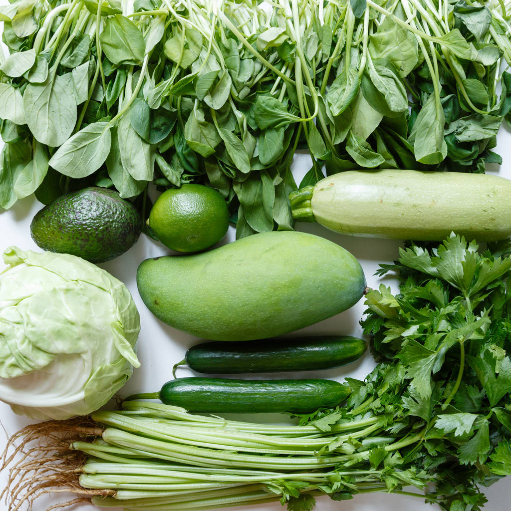 Fresh green vegetables variety on rustic white background from overhead, celery, avocado, cabbage, mango, cucumber, spinach, lime, squash. Healthy, vegetarian concept. Flat lay, top view - Photo, Image