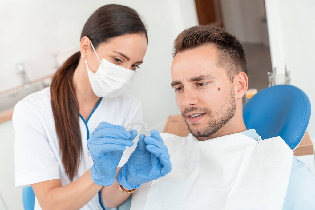 Dentysta pokazuje niewidoczne szelki Aligner - Zdjęcie, obraz