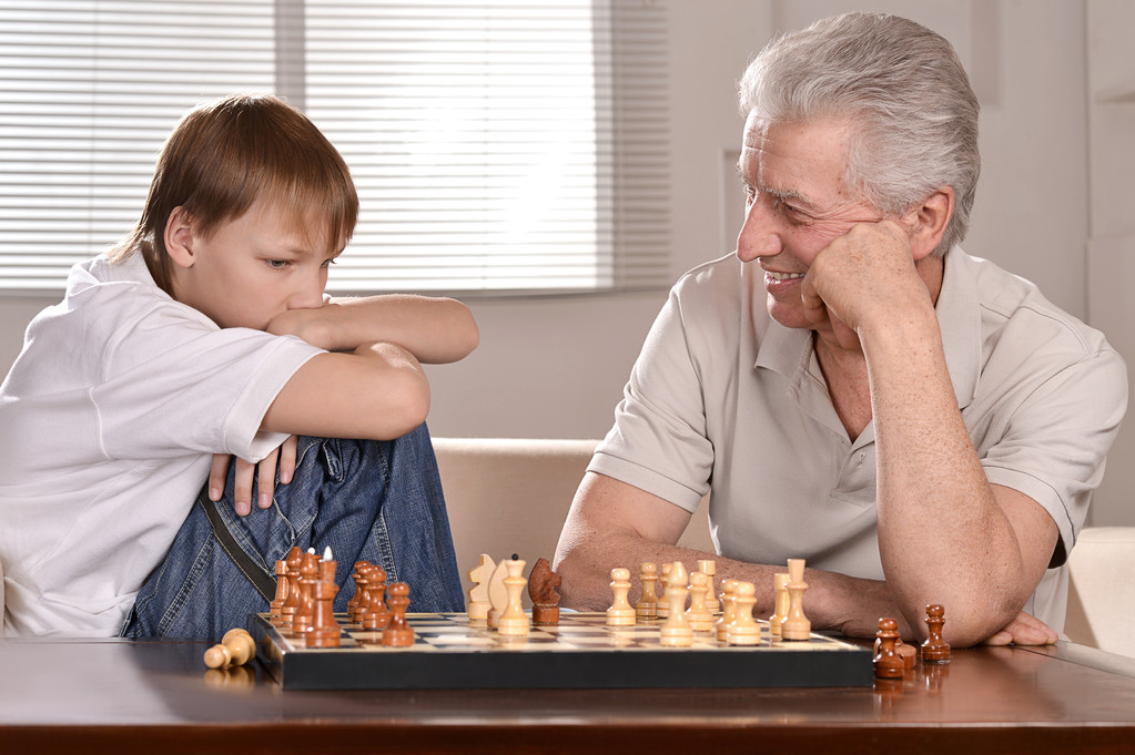 Мальчик и дедушка играют в шахматы
 - Фото, изображение