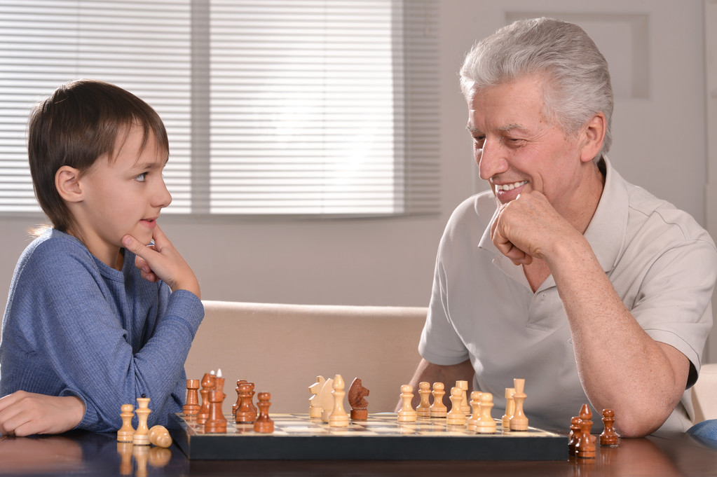 Boy and grandfather playing chess - Photo, Image
