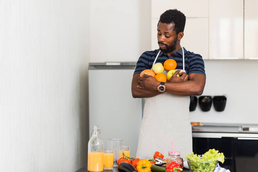 African man preparing healthy food at home in kitchen - Photo, Image