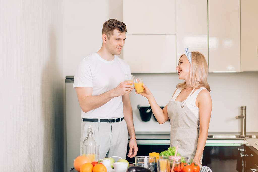 Couple making fresh organic juice in kitchen together - Photo, Image