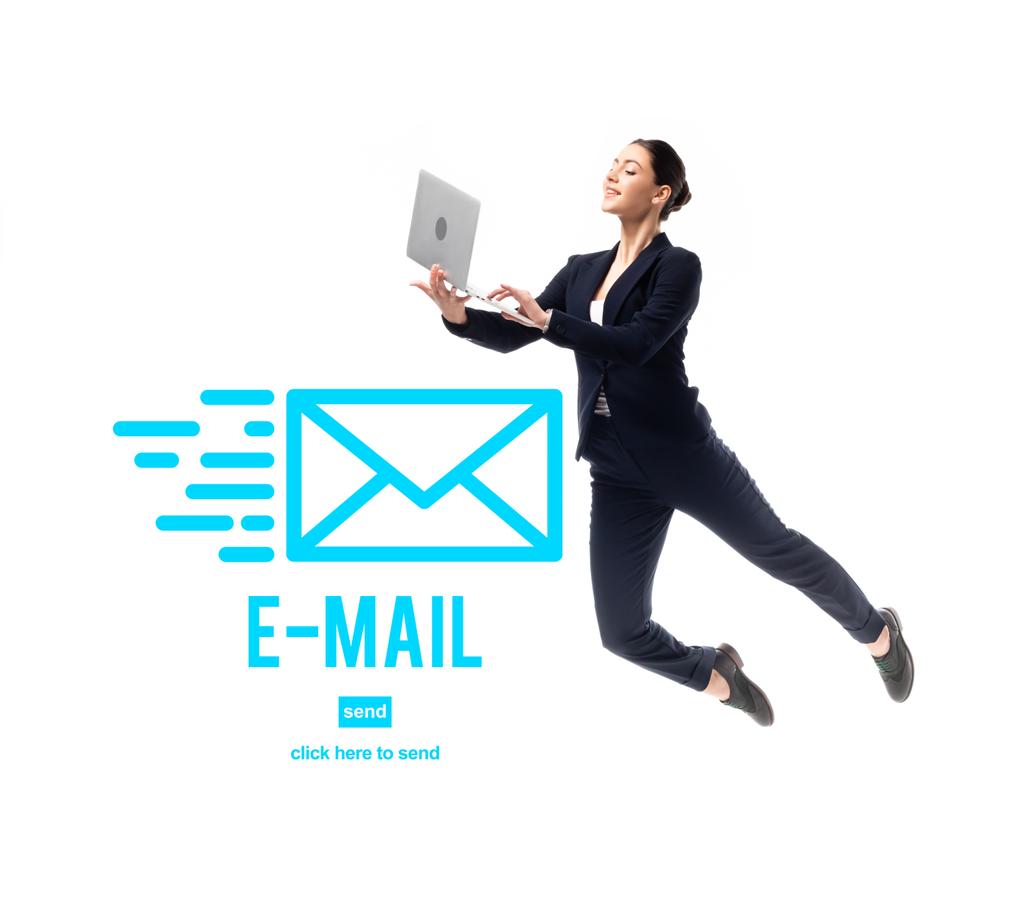 smiling businesswoman levitating while using laptop near e-mail icon and click here to send lettering isolated on white - Photo, Image