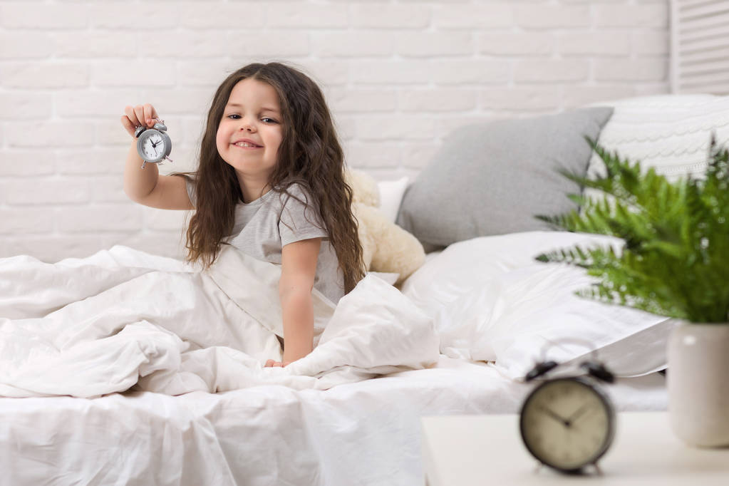 Saat ile pijama küçük kız - Fotoğraf, Görsel