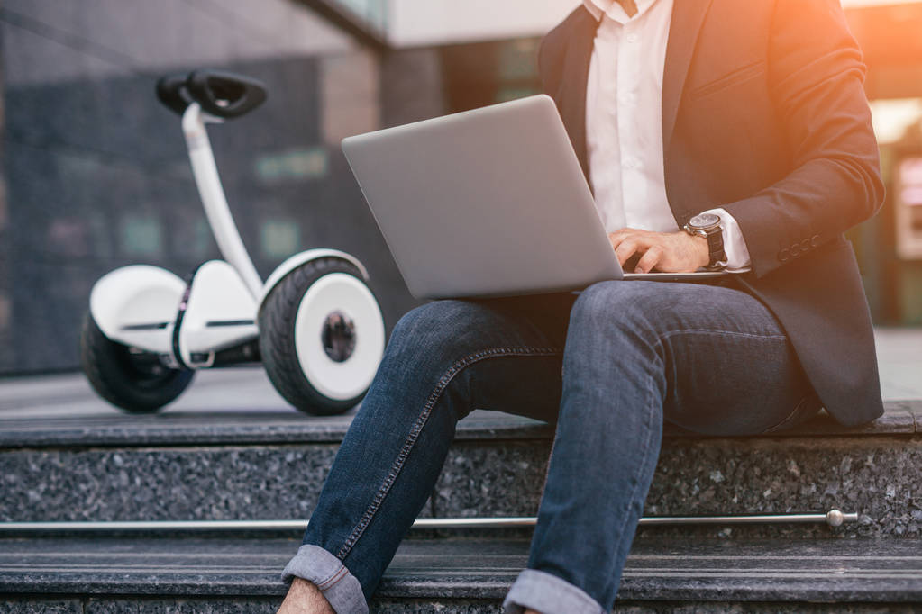 Cultiver homme d'affaires en utilisant un ordinateur portable près gyroscooter
 - Photo, image