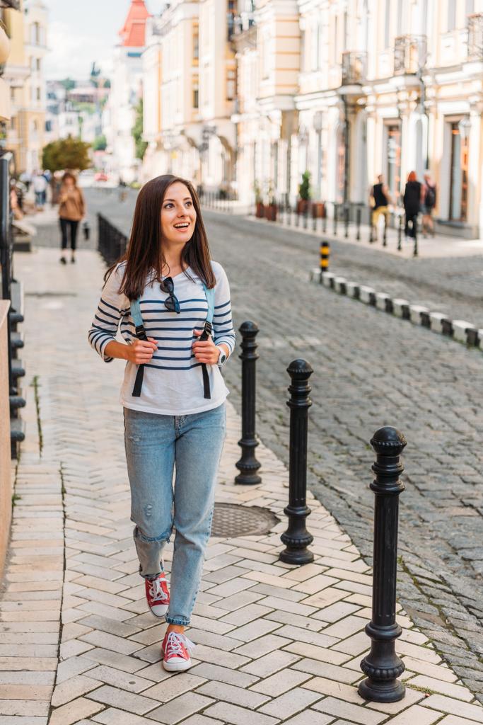 felice giovane donna a piedi con lo zaino vicino agli edifici
  - Foto, immagini