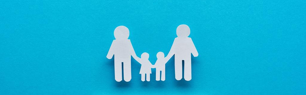 tiro panorâmico de corte de papel família segurando as mãos no fundo azul
 - Foto, Imagem