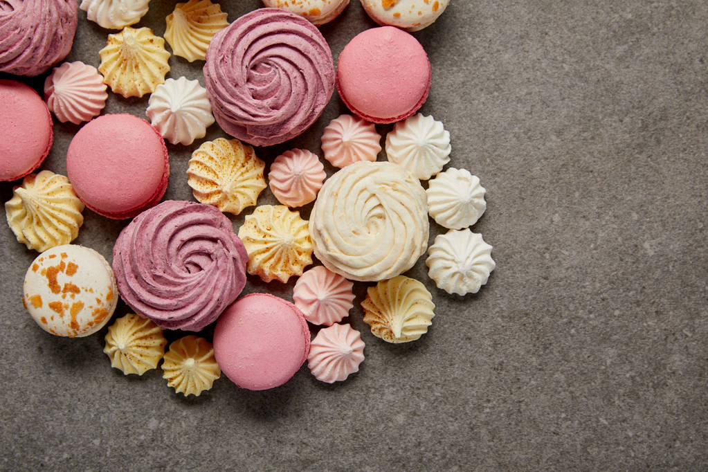 Vue de dessus des meringues, macarons et zéphyr blanc et rose moelleux sur fond gris
 - Photo, image