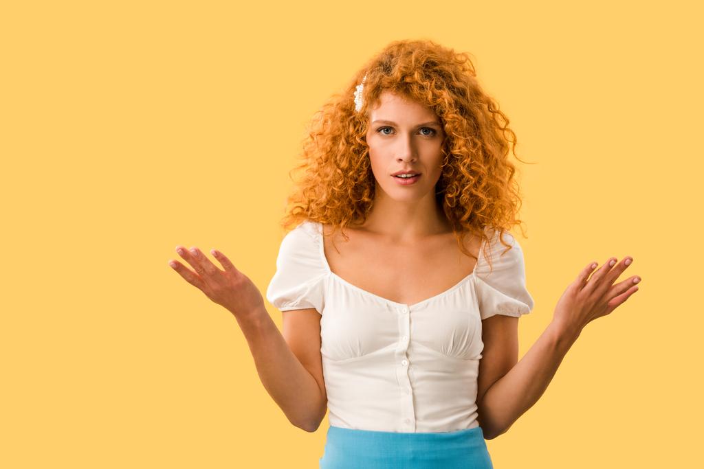 confused redhead woman with shrug gesture, isolated on yellow - Photo, Image