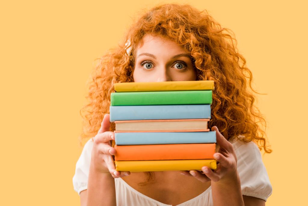 női vöröshajú diák gazdaság könyvek elszigetelt sárga  - Fotó, kép