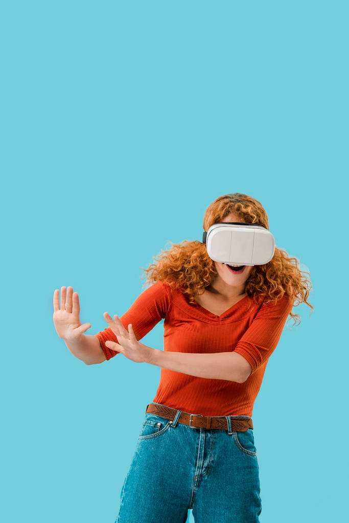 mooie vrouw in Virtual Reality headset geïsoleerd op blauw - Foto, afbeelding