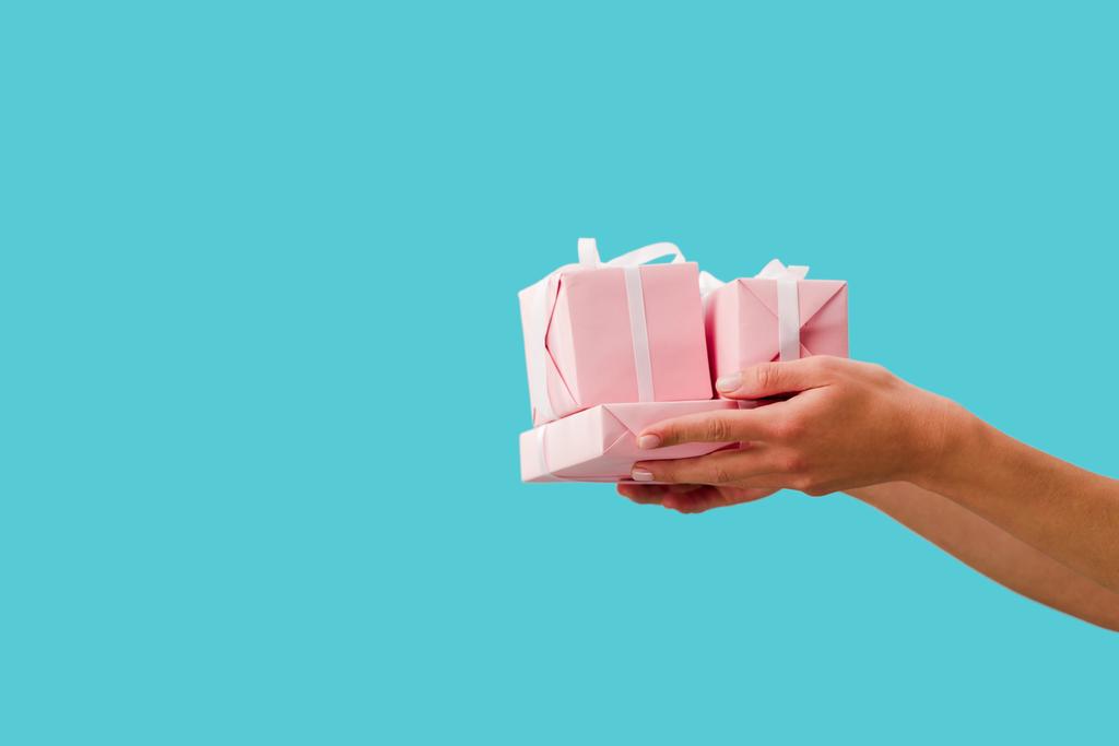 cropped view of girl holding presents in hands isolated on blue - Photo, Image