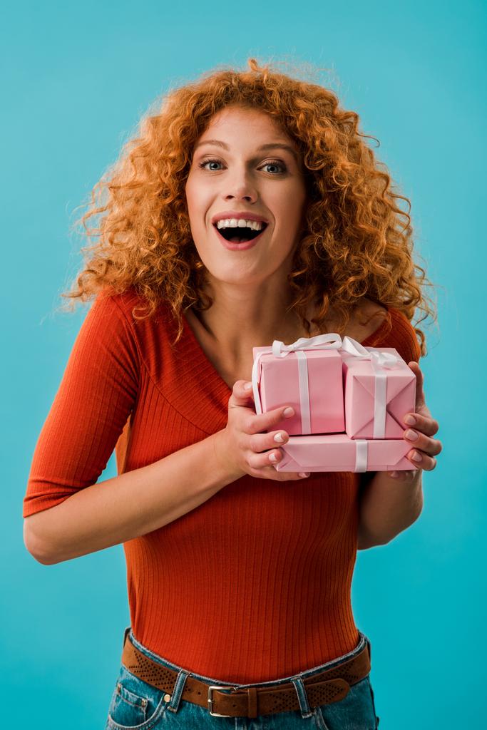 beautiful excited girl holding gifts isolated on blue - Photo, Image