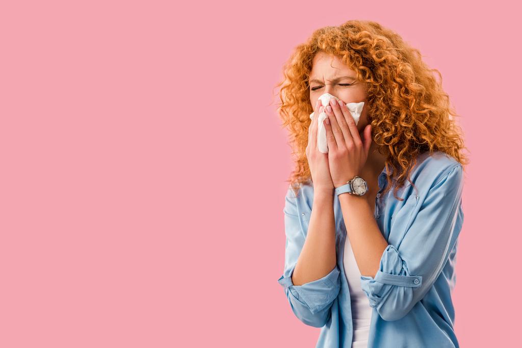 mujer pelirroja enferma estornudando con servilletas de papel, aislado en rosa
 - Foto, imagen