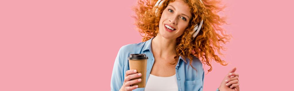 rousse femme avec café pour aller danser et écouter de la musique dans les écouteurs, isolé sur rose
 - Photo, image