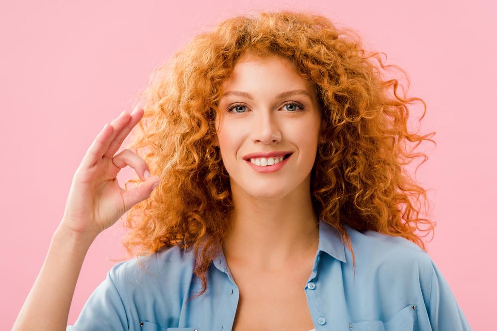 hymyilevä houkutteleva punapää tyttö osoittaa ok merkki eristetty vaaleanpunainen
 - Valokuva, kuva
