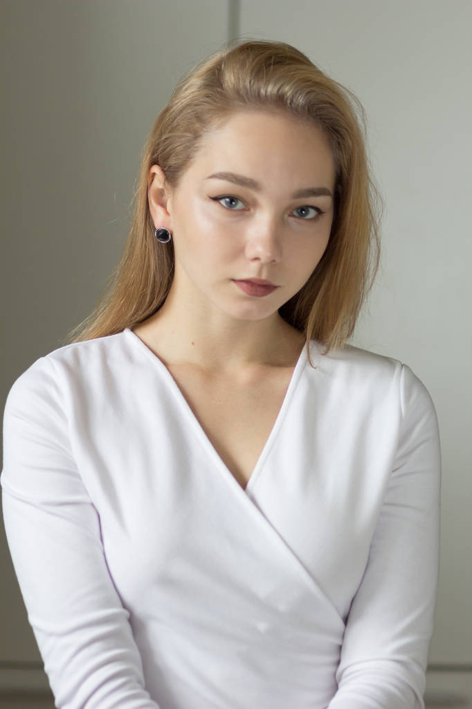 Portrét nádherné mladé ženy v bílých šatech, které se dívají na kameru - Fotografie, Obrázek