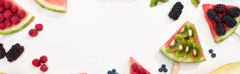 panoramic shot of delicious watermelon on sticks with berries and kiwi on white background - Photo, Image