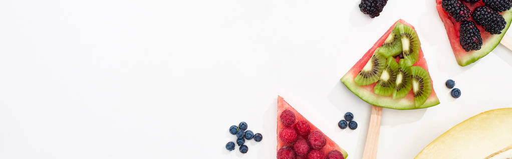 tiro panorâmico de melancia em paus com bagas doces e kiwi no fundo branco
 - Foto, Imagem