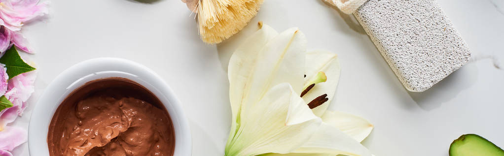 πανοραμική φωτογραφία της μάσκας από καφέ πηλό, ελαφρόπετρα και λευκό λουλούδι σε μαρμάρινη επιφάνεια - Φωτογραφία, εικόνα