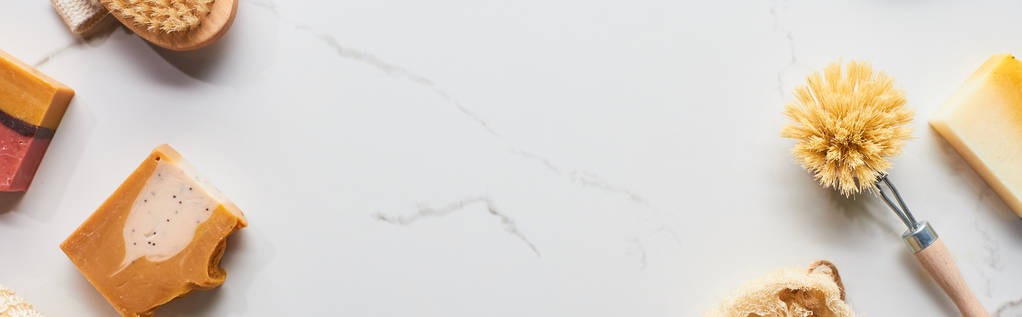 panoramatický záběr kartáčů na tělo a přírodních mýdlových kousků na povrchu mramoru - Fotografie, Obrázek