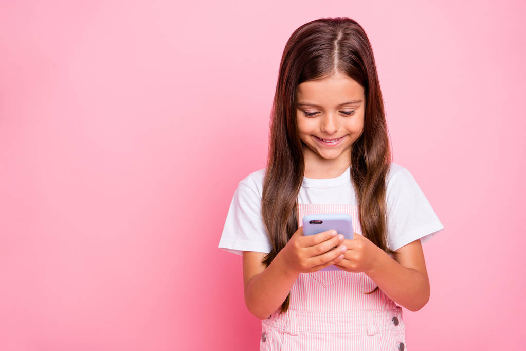 小さな女性の休日の時間のクローズアップ写真は、新しい電話ライティング友人が全体的に孤立したピンクの背景を着用を保持します - 写真・画像