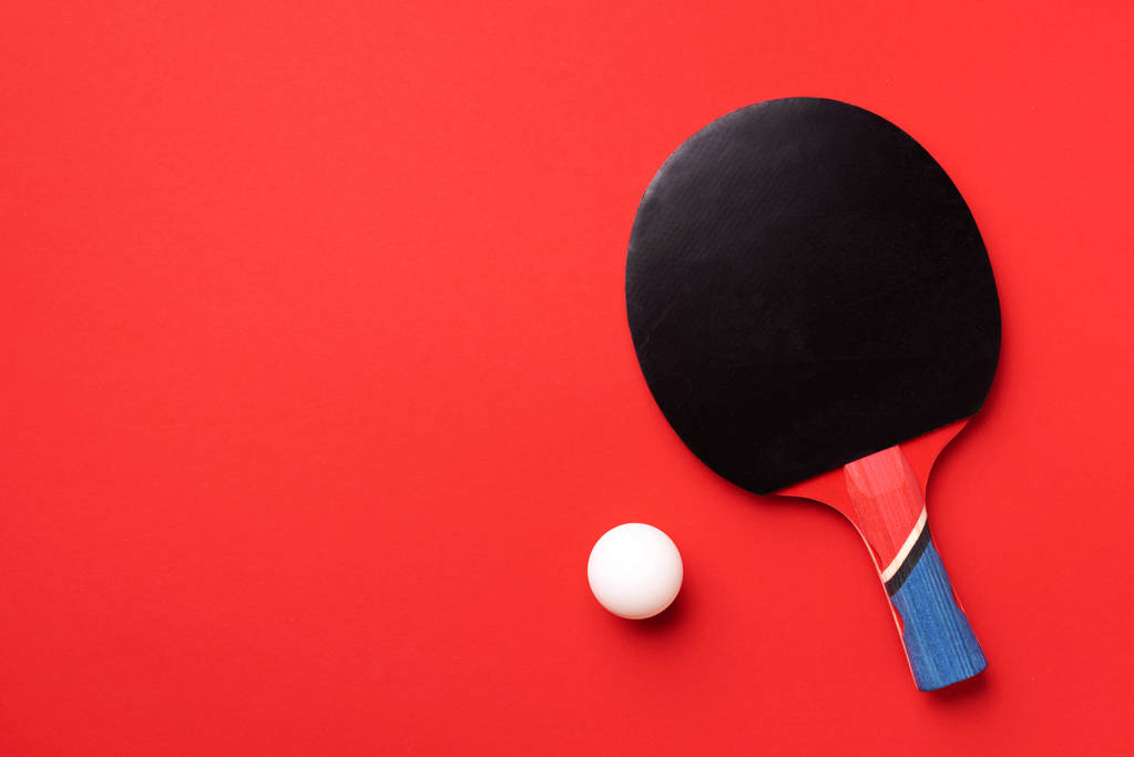 Sport, fitness, egészséges életmód koncepció. Ping-pong vagy asztalitenisz ütők és fehér labda piros háttérrel. Első látásra. Lapos fektetés. - Fotó, kép
