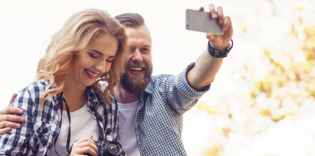 Sonbahar parkında selfie çeken genç bir çift. Aşk, ilişkiler ve tarih kavramı. - Fotoğraf, Görsel