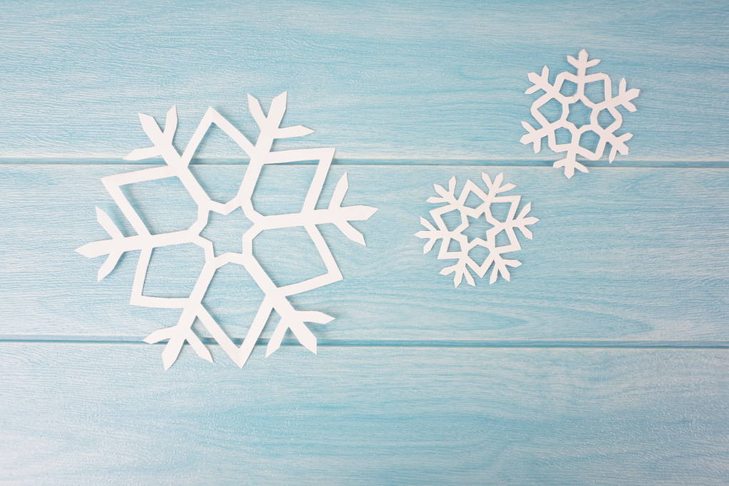 flocos de neve de papel de origami na superfície da mesa de madeira azul, vista superior
  - Foto, Imagem