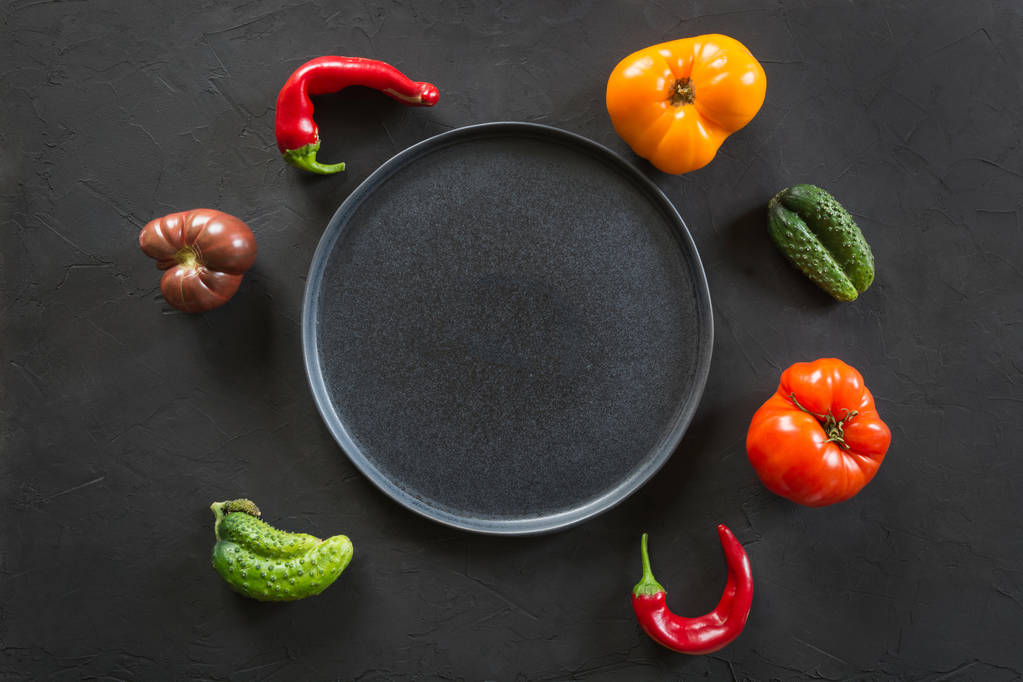 Feo tomate colorido orgánico, pimienta, pepino en negro. Concepto verduras ecológicas
. - Foto, Imagen