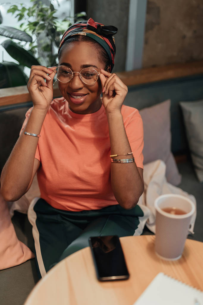 Młoda Afro-amerykańska kobieta nosi okulary w kawiarni - Zdjęcie, obraz