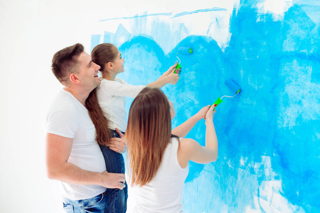 Matka, otec a dcera malují zeď v novém domově. - Fotografie, Obrázek