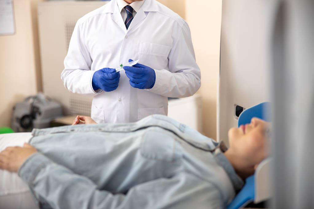 Médecin debout à côté du patient et tenant un cathéter
 - Photo, image