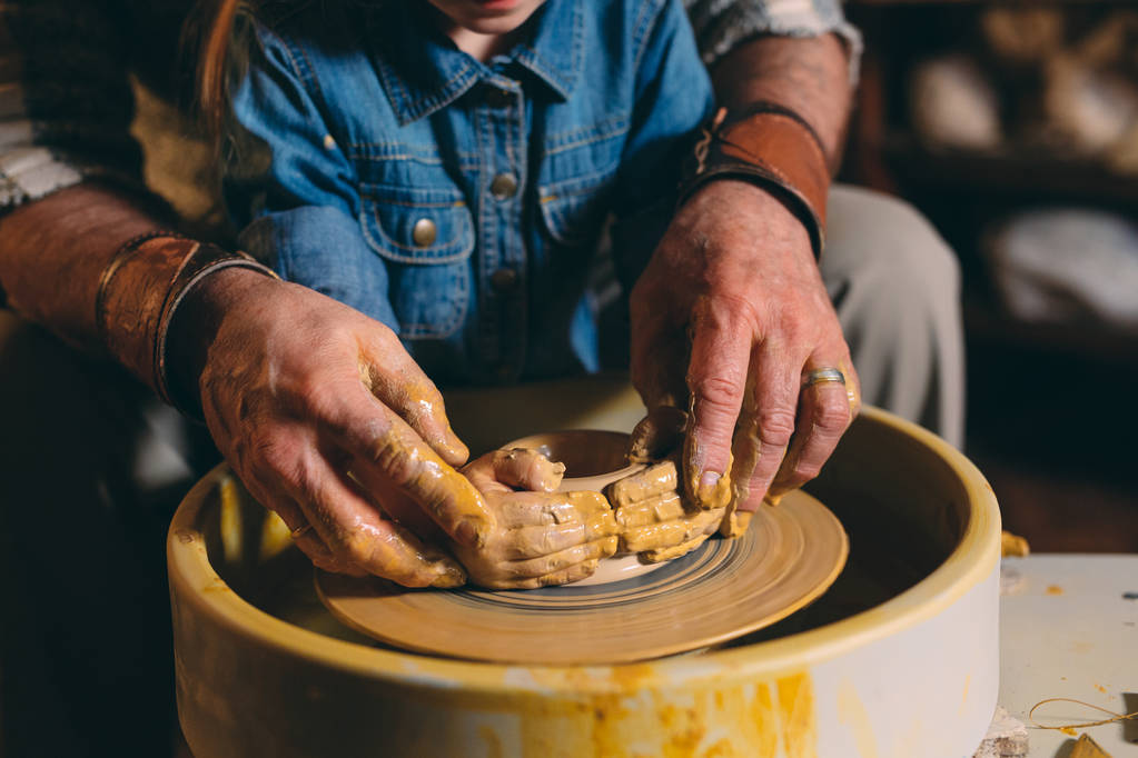 Atelier de poterie. Grand-père enseigne la poterie à petite-fille. Modélisation de l'argile - Photo, image