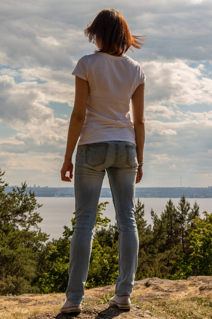Lány áll egy szikla a tenger ellen - Fotó, kép