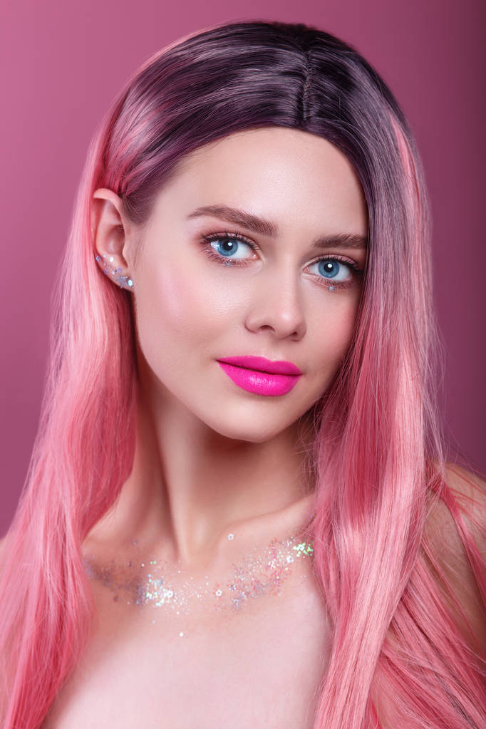Красивая модель девушка с окрашенными в розовый цвет волосами. Девушка с ярким макияжем и розовыми губами
 . - Фото, изображение