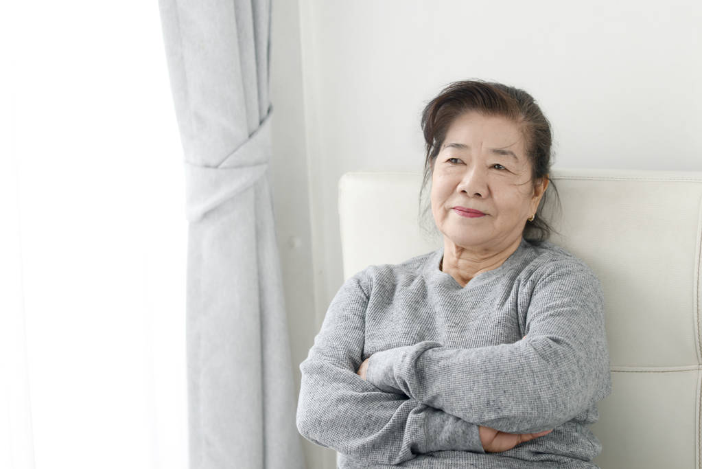 Gelukkig Aziatische Senior vrouw ontspannen op de Bank thuis, Lifestyle con - Foto, afbeelding